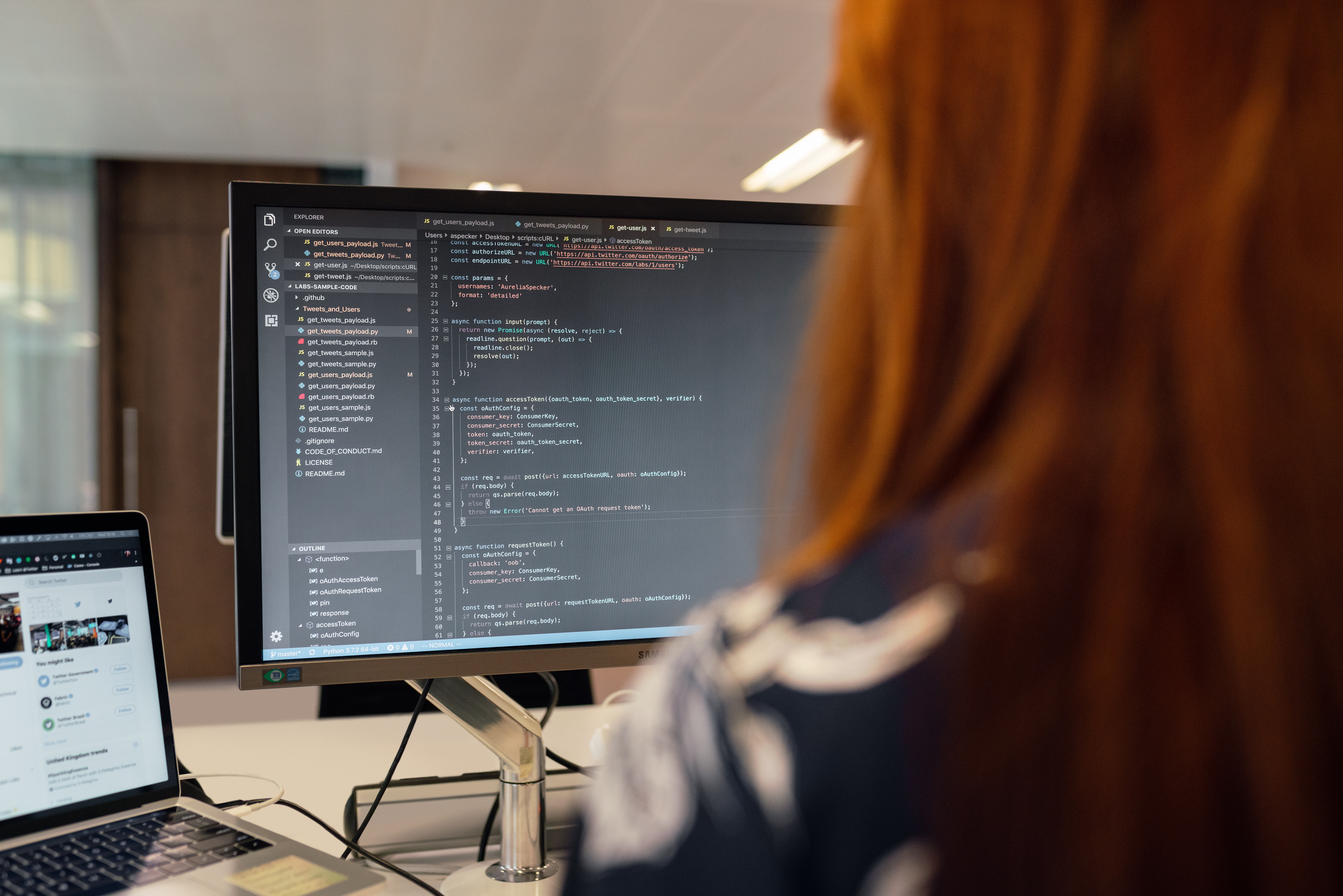Woman looking at a monitor showing code